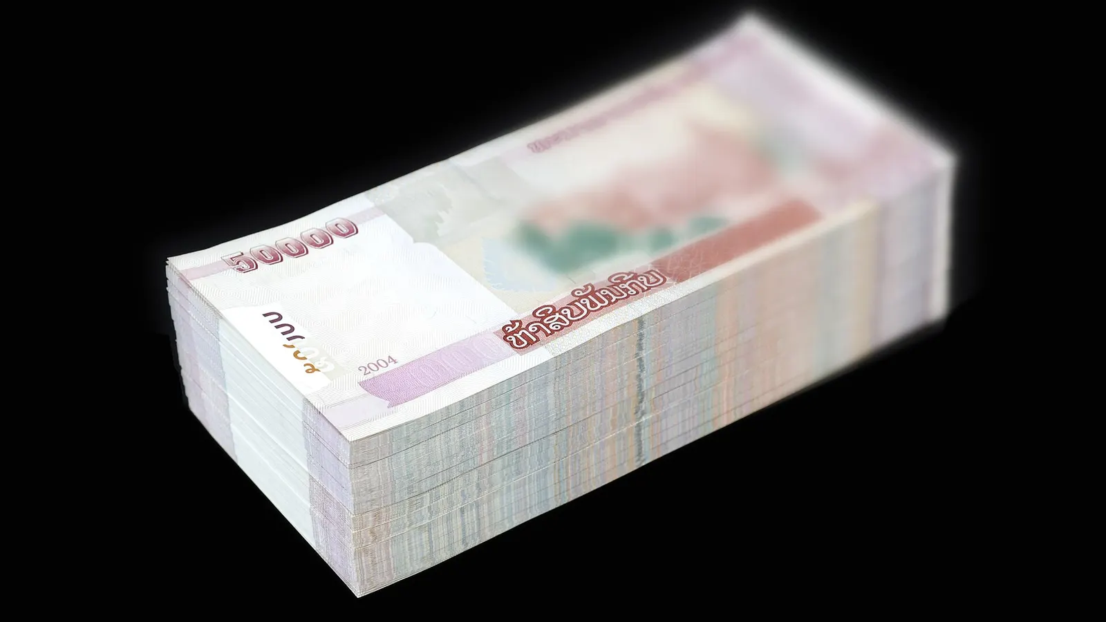 Liasse de billets de banque empilés sur fond noir
